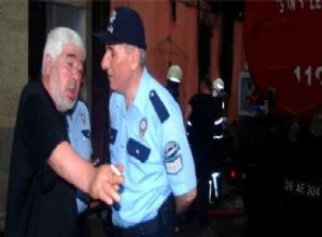 Yanan evini elindeki içki şişesiyle izledi