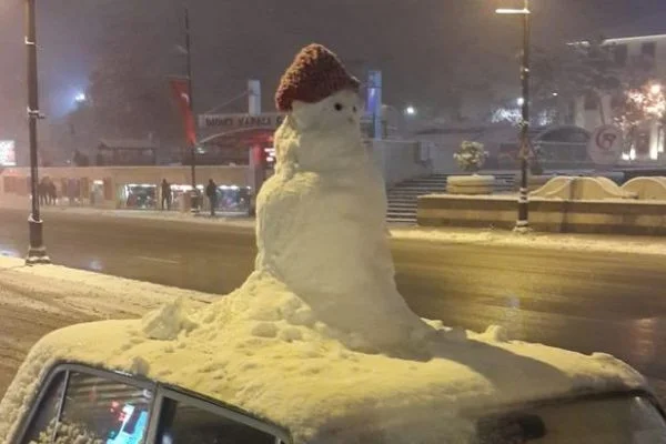 Arabanın tavanına yaptığı kardan adamla şehir turu attı