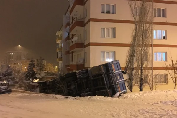 Karda kayan kamyon apartman bahçesine devrildi