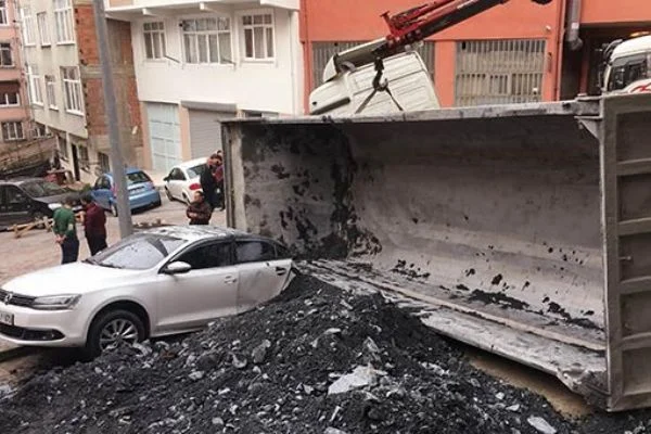 Yük boşaltan hafriyat kamyonu otomobilin üzerine devrildi