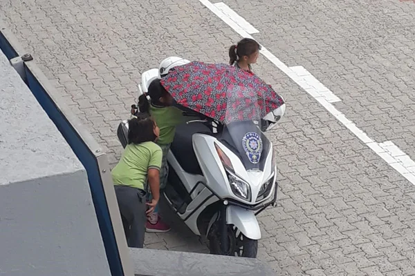 Polis motosikletini yağmurdan koruyan öğrenciye ödül