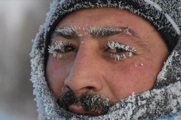 Kars'ta kaşı, kirpikleri, bıyığı buz tutan vatandaş soğuk hava çilesine mani koştu