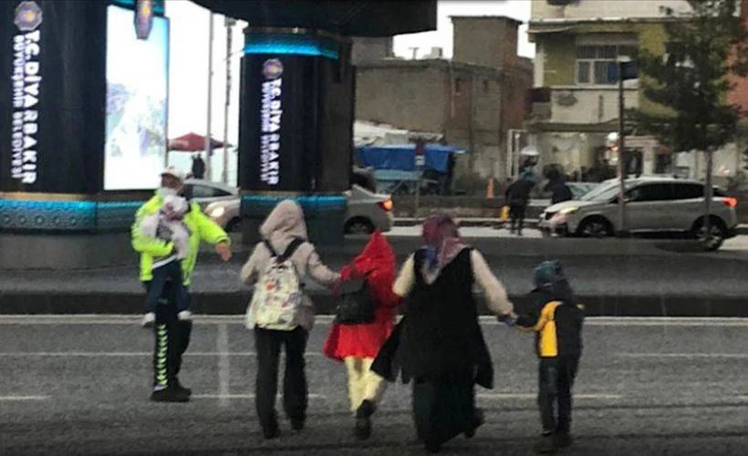 Diyarbakır'da doluya yakalanan anne ve çocukları trafik polisinin yardımıyla yolun karşısına geçti